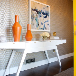 Immagine di un corridoio moderno di medie dimensioni con pareti con effetto metallico, parquet scuro, una porta a pivot e una porta gialla