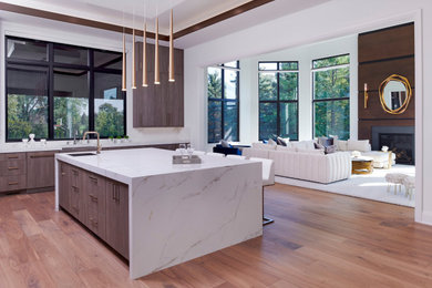 Inspiration for a huge transitional l-shaped light wood floor and brown floor eat-in kitchen remodel in Detroit with a farmhouse sink, flat-panel cabinets, dark wood cabinets, quartzite countertops, white backsplash, quartz backsplash, stainless steel appliances, an island and white countertops