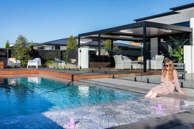 Foto de piscina minimalista rectangular en patio delantero con paisajismo de piscina y losas de hormigón