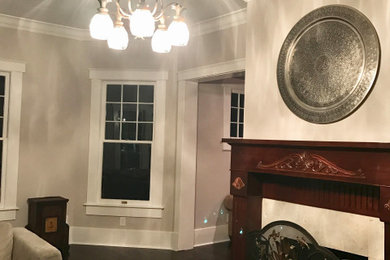 Example of a large transitional formal and open concept medium tone wood floor and brown floor living room design in Tampa with gray walls, a standard fireplace and a wood fireplace surround