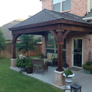 Small arts and crafts backyard patio in Dallas with concrete slab and a roof extension.