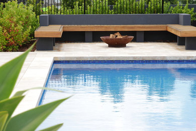Inspiration for an expansive contemporary backyard rectangular pool in Sydney with a pool house and natural stone pavers.