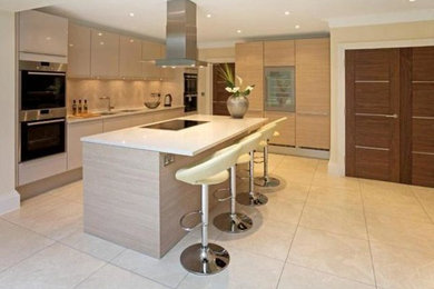 Contemporary l-shaped open plan kitchen in Brisbane with flat-panel cabinets, light wood cabinets, beige splashback, stainless steel appliances, with island and a double-bowl sink.