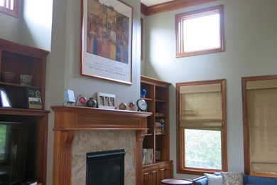 Transitional open concept medium tone wood floor living room photo in Minneapolis with green walls, a standard fireplace and a stone fireplace