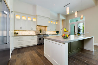 Inspiration for a mid-sized transitional l-shaped medium tone wood floor and brown floor eat-in kitchen remodel in Miami with an undermount sink, recessed-panel cabinets, white cabinets, quartz countertops, multicolored backsplash, glass tile backsplash, stainless steel appliances and an island