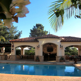 Bild på en mellanstor medelhavsstil rektangulär pool på baksidan av huset, med poolhus och stämplad betong