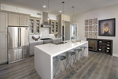 Design ideas for a contemporary kitchen in Phoenix with a farmhouse sink, glass-front cabinets, grey cabinets, white splashback, stainless steel appliances and with island.