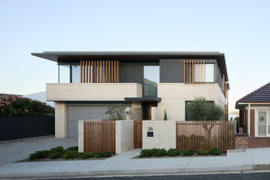 Inspiration for a contemporary two-storey brick beige house exterior in Newcastle - Maitland with a flat roof.
