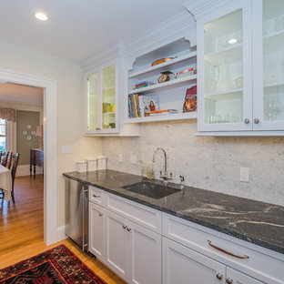 Large contemporary l-shaped kitchen pantry in New York with an undermount sink, recessed-panel cabinets, white cabinets, granite benchtops, white splashback, stone tile splashback, stainless steel appliances, medium hardwood floors and with island.