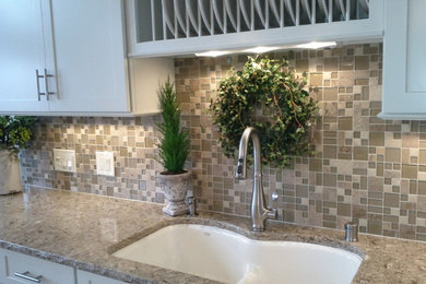 Kitchen - porcelain tile kitchen idea in Seattle with an undermount sink, white cabinets, quartz countertops, beige backsplash and stone tile backsplash