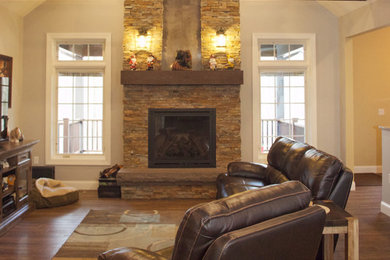 Family room - mid-sized rustic enclosed medium tone wood floor and brown floor family room idea in Philadelphia with gray walls, a standard fireplace, a stone fireplace and a wall-mounted tv