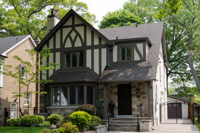 Elegant white two-story exterior home photo in Toronto with a shingle roof and a brown roof