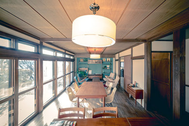 Immagine di una grande sala da pranzo moderna con parquet scuro, nessun camino, pavimento marrone e pareti beige