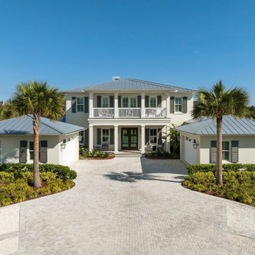 Symmetrical Coastal Home Exterior with Palm-lined Drive