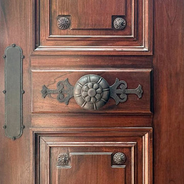 We are designers and builders of carved wood doors with wrought metal appliqués.