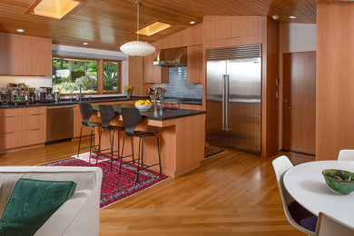 Mid-sized 1950s l-shaped light wood floor, brown floor and wood ceiling open concept kitchen photo in Los Angeles with an undermount sink, flat-panel cabinets, light wood cabinets, granite countertops, blue backsplash, ceramic backsplash, stainless steel appliances, an island and black countertops