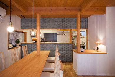 Photo of a modern open plan dining in Kobe with white walls, medium hardwood floors and brown floor.