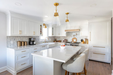 Example of a mid-sized transitional u-shaped medium tone wood floor eat-in kitchen design in New York with a farmhouse sink, shaker cabinets, white cabinets, quartz countertops, blue backsplash, mosaic tile backsplash, paneled appliances, an island and white countertops