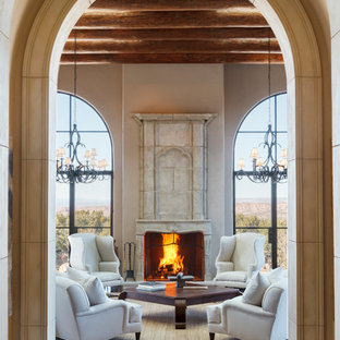 Modelo de salón para visitas abierto, mediterráneo, extra grande, sin televisor, con paredes beige, suelo de madera oscura, chimenea tradicional y marco de chimenea de piedra