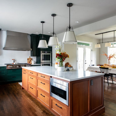 Eat-in kitchen - mid-sized transitional l-shaped dark wood floor and brown floor eat-in kitchen idea in Seattle with a farmhouse sink, shaker cabinets, green cabinets, white backsplash, subway tile backsplash, paneled appliances, an island, green countertops and quartz countertops