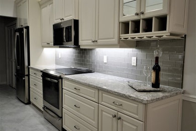 Mid-sized traditional galley eat-in kitchen in Miami with an undermount sink, raised-panel cabinets, white cabinets, quartzite benchtops, grey splashback, stainless steel appliances, ceramic floors, no island, grey floor and grey benchtop.