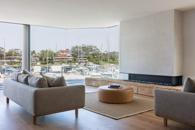 Foto di un soggiorno minimal di medie dimensioni con pareti beige, pavimento in legno massello medio, camino lineare Ribbon e pavimento marrone