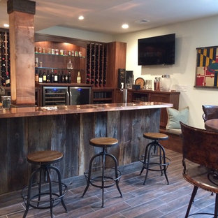 ワシントンD.C.の大きいインダストリアルスタイルのおしゃれな着席型バー (アンダーカウンターシンク、落し込みパネル扉のキャビネット、中間色木目調キャビネット、銅製カウンター、磁器タイルの床) の写真