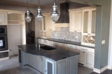 Mid-sized transitional u-shaped ceramic tile and gray floor eat-in kitchen photo in Wichita with a double-bowl sink, raised-panel cabinets, white cabinets, granite countertops, metallic backsplash, ceramic backsplash, stainless steel appliances and an island