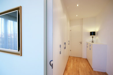 Modernes Hauptschlafzimmer mit weißer Wandfarbe und hellem Holzboden in Leipzig