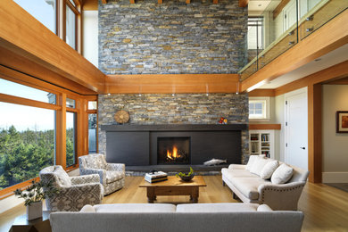 This is an example of a large transitional open concept living room in Other with beige walls, medium hardwood floors, a standard fireplace, a stone fireplace surround and a concealed tv.