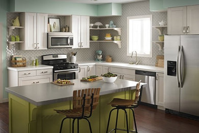 Inspiration for a mid-sized timeless l-shaped dark wood floor eat-in kitchen remodel in Cleveland with white cabinets, gray backsplash, stainless steel appliances and an island