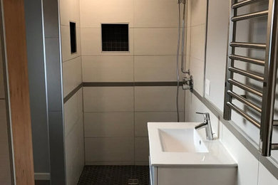 Medium sized modern ensuite bathroom in Portland with flat-panel cabinets, white cabinets, an alcove bath, an alcove shower, grey tiles, white tiles, porcelain tiles, white walls, porcelain flooring, an integrated sink, engineered stone worktops, grey floors, an open shower and white worktops.