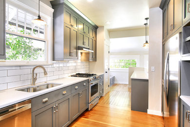 Inspiration for a small modern galley light wood floor kitchen remodel in Boise with an undermount sink, shaker cabinets, gray cabinets, white backsplash, subway tile backsplash and stainless steel appliances