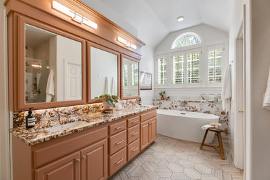 Inspiration for a large eclectic master multicolored tile and ceramic tile porcelain tile, gray floor, double-sink and vaulted ceiling bathroom remodel in Portland with raised-panel cabinets, brown cabinets, a one-piece toilet, white walls, a drop-in sink, granite countertops, a hinged shower door, multicolored countertops, a niche and a built-in vanity