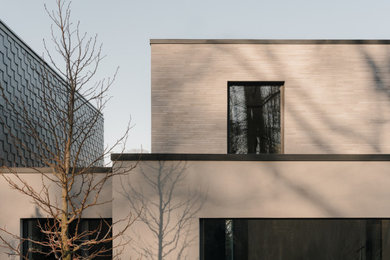 Réalisation d'une façade de maison minimaliste avec un toit plat et un toit végétal.