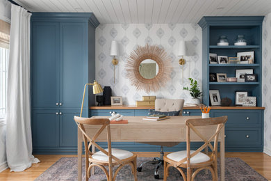 Ejemplo de despacho marinero con paredes blancas, suelo de madera en tonos medios, escritorio independiente, suelo marrón y papel pintado