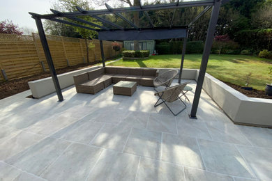 Photo of a large contemporary patio in Hertfordshire with tiled flooring.