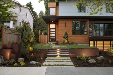 Inspiration for a mid-sized modern front yard full sun driveway for spring in Seattle with a retaining wall and brick pavers.