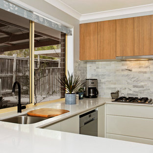 Пример оригинального дизайна: п-образная кухня среднего размера в современном стиле с кладовкой, врезной раковиной, плоскими фасадами, белыми фасадами, столешницей из кварцевого композита, серым фартуком, фартуком из плитки кабанчик, техникой из нержавеющей стали, паркетным полом среднего тона, полуостровом и желтым полом