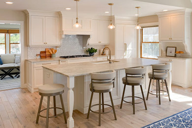Large transitional l-shaped light wood floor and brown floor eat-in kitchen photo in Minneapolis with an undermount sink, shaker cabinets, white cabinets, gray backsplash, an island and beige countertops