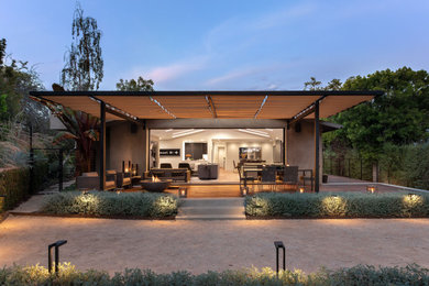 Example of a trendy ground level deck design in Los Angeles with a pergola