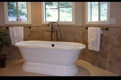 Elegant beige tile and ceramic tile ceramic tile and beige floor freestanding bathtub photo in Seattle with beige walls