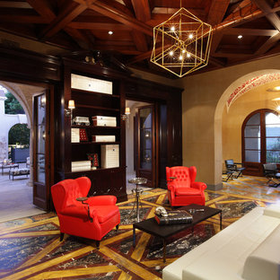 Modelo de biblioteca en casa abierta, mediterránea, grande, con paredes beige y suelo de mármol