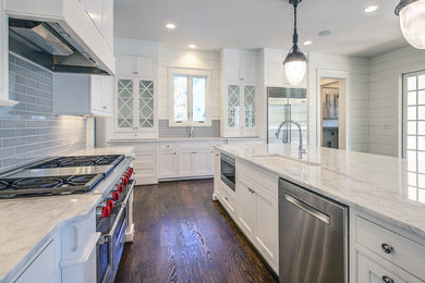This is an example of a large country l-shaped eat-in kitchen in Atlanta with a farmhouse sink, shaker cabinets, white cabinets, marble benchtops, grey splashback, glass tile splashback, stainless steel appliances, dark hardwood floors and with island.