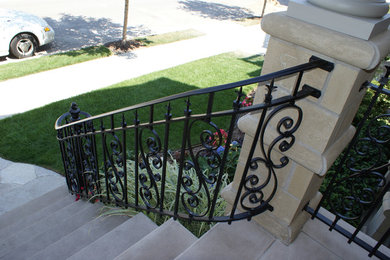 Solid stone stairs with ornamental iron railing
