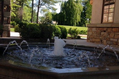 Example of a small classic courtyard patio fountain design in Other