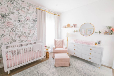 Design ideas for a mid-sized transitional nursery for girls in Los Angeles with white walls.