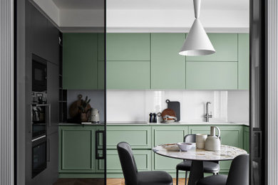 Immagine di una cucina minimal con ante verdi, top in superficie solida, paraspruzzi bianco, paraspruzzi con lastra di vetro e top bianco