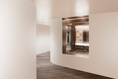 Photo of a contemporary wine cellar in San Francisco with dark hardwood floors, storage racks and brown floor.