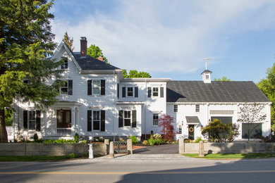 Large country two-storey white exterior in Boston with wood siding and a gable roof.